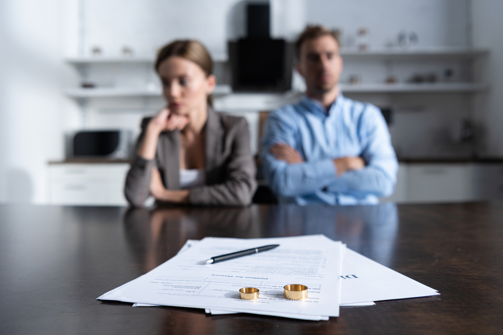 couple facing divorce documents withe their wedding rings on top - filing for divorce in Oregon